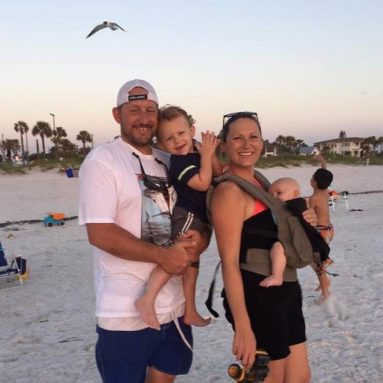 Family photo of Captain Erich Jaeger and his wife, Abby Jaeger, with their two boys on the beach